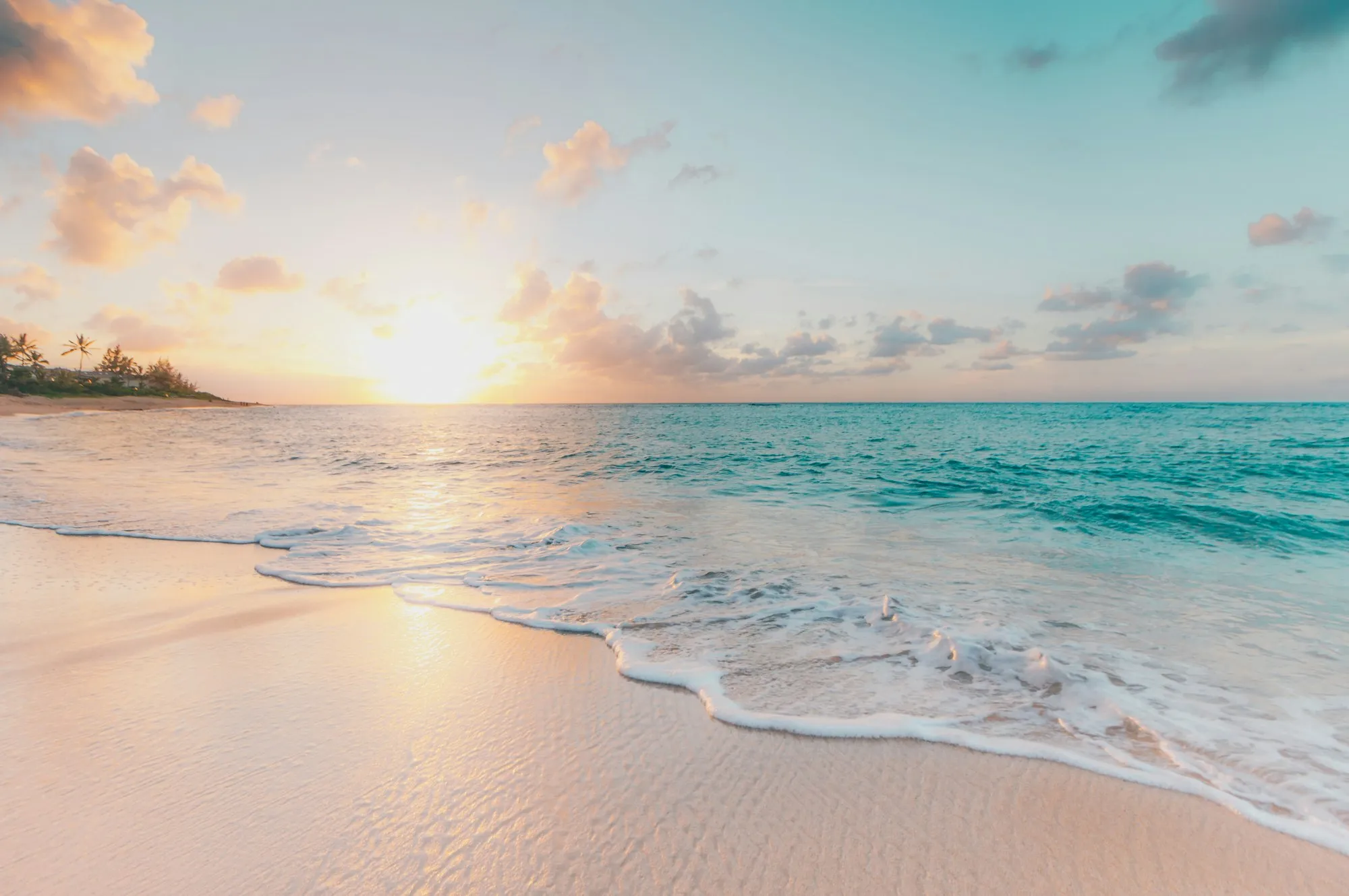 Waves on a white sand beach at sunrise